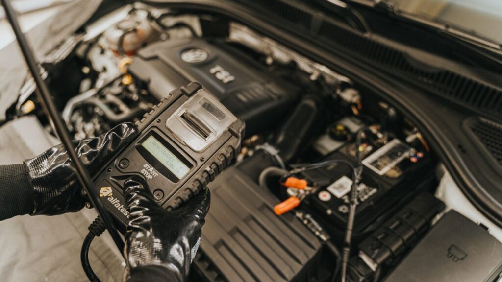 BMW variklio valdymo blokas mechaniko rankose automobilių remonto dirbtuvėse