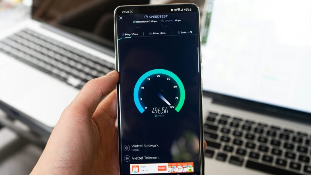 Ranka laiko išmanųjį telefoną, kuriame tikrinamas interneto ryšio greitis