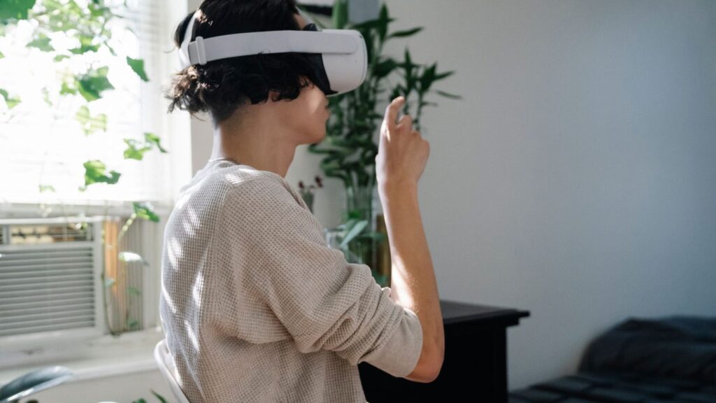 Žmogus su virtualios realybės akiniais mato kambario interjerą, kurį kuria skaitmeniniu būdu