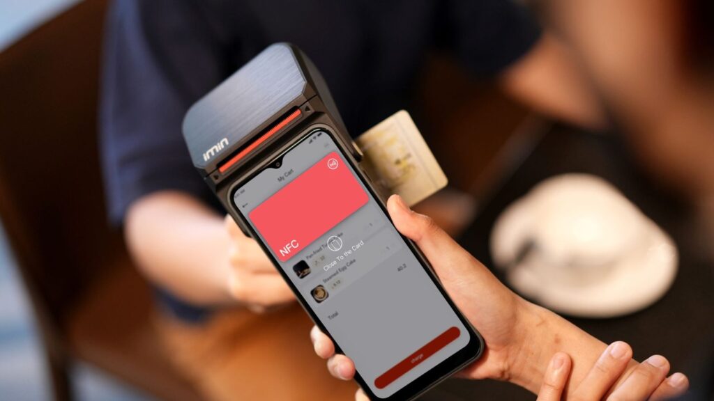 Telefonas prilaikomas prie mokėjimo terminalo – bekontaktis mokėjimas per NFC