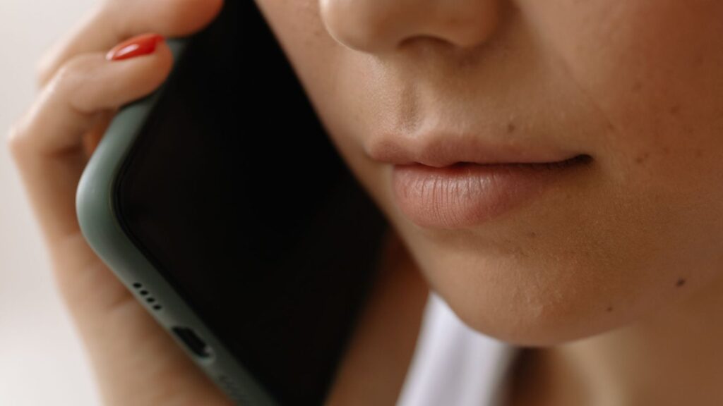 Ranka laiko išmanusis telefonas su ryšio stiprumo rodikliu ekrane