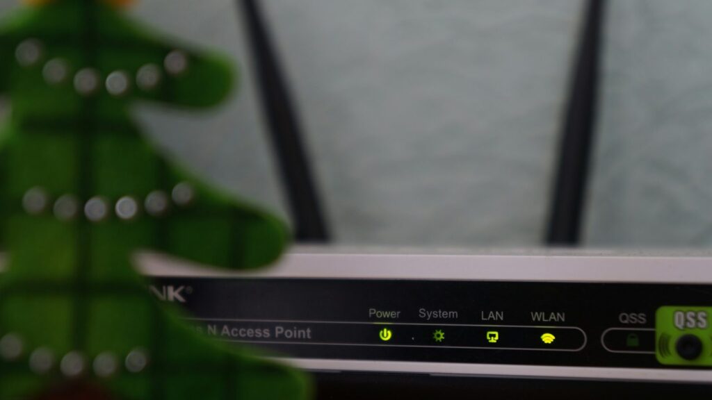 Wi-Fi maršrutizatorius su mirksinčiomis lemputėmis ant medinės lentynos svetainėje
