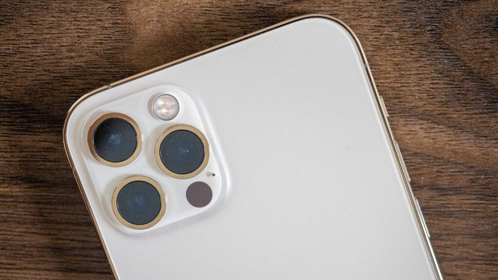 iPhone prilipęs prie magnetinio belaidžio įkroviklio ant stalo