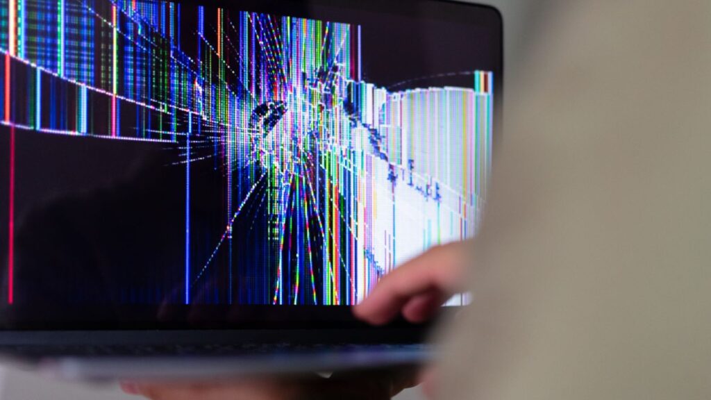 Technikas keičia nešiojamojo kompiuterio ekraną remonto dirbtuvėse