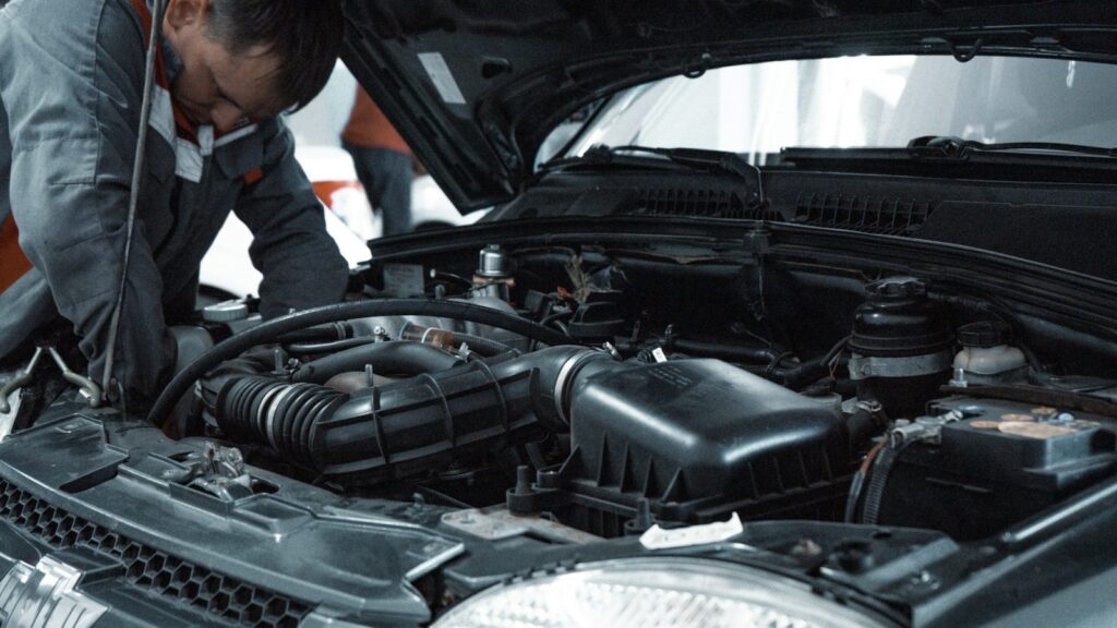 Automobilis techninės apžiūros metu, mechanikas tikrina automobilio būklę servise
