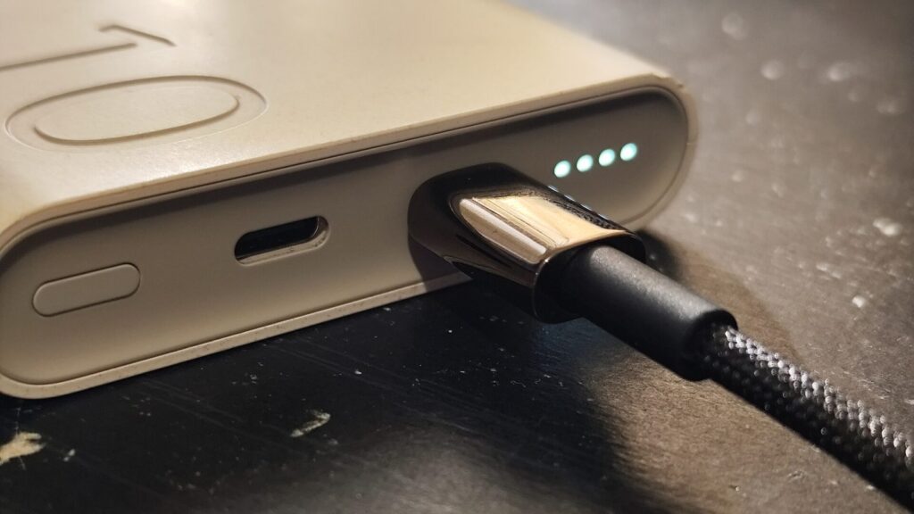 USB-C kabelis, įkištas į išmanųjį telefoną, greito įkrovimo akcentas