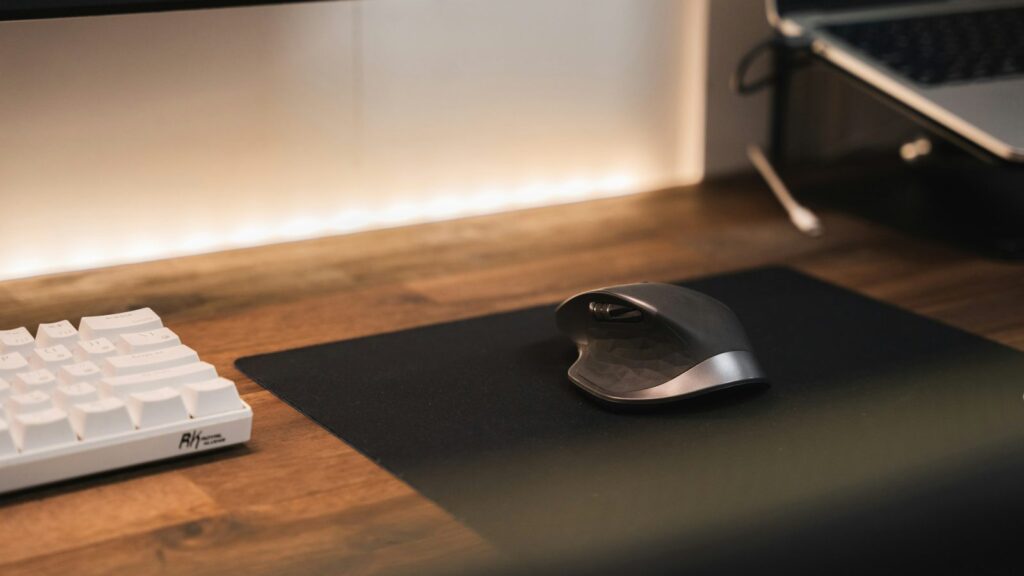 Ranka ant vertikalios ergonominės pelės ant darbo stalo, natūrali riešo padėtis
