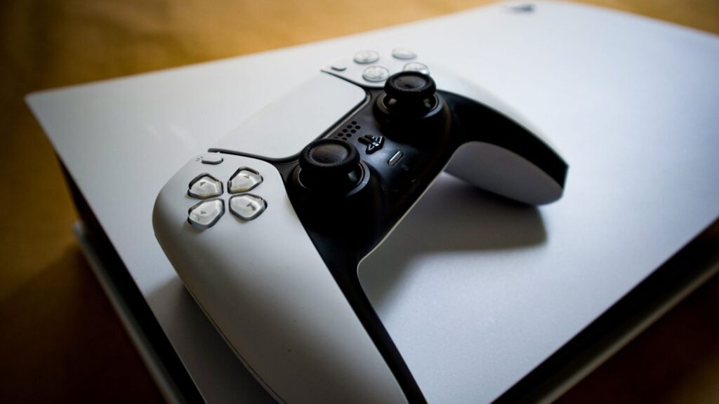 PlayStation 5 konsolė su atidarytu šonu ir M.2 SSD diskas prieš įdedant į vidinį lizdą