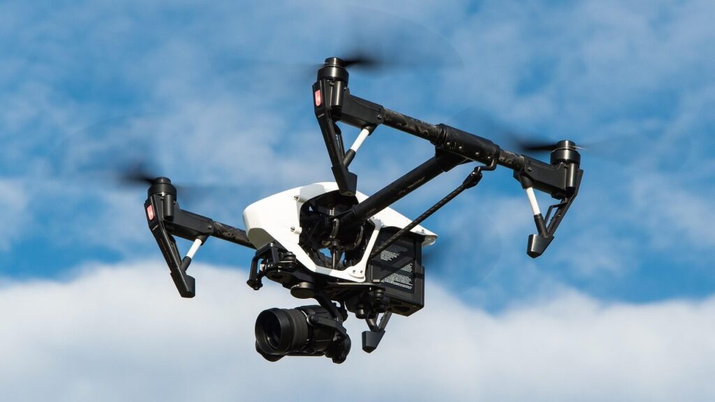 MicroSD atminties kortelė šalia dronо kameros, skirta 4K vaizdo įrašymui
