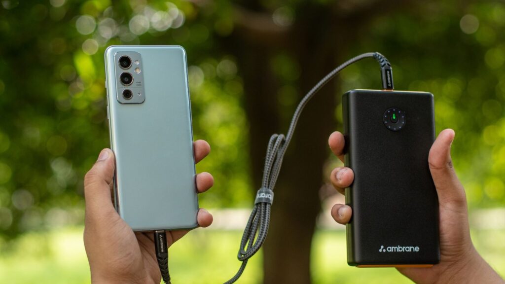 Powerbank su USB kabeliu, prijungtas prie išmaniojo telefono kelionėje