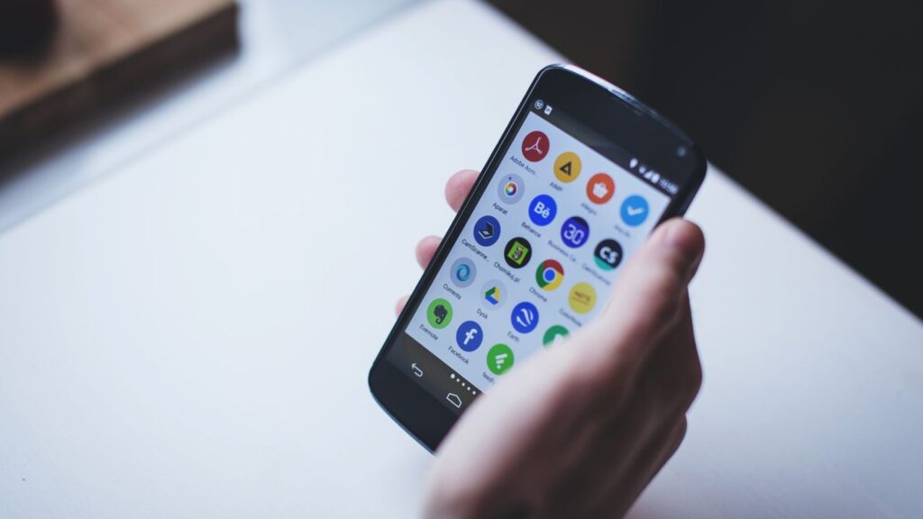 Ranka laiko Android telefoną, ekrane matosi lėtai atsidarančios programėlės