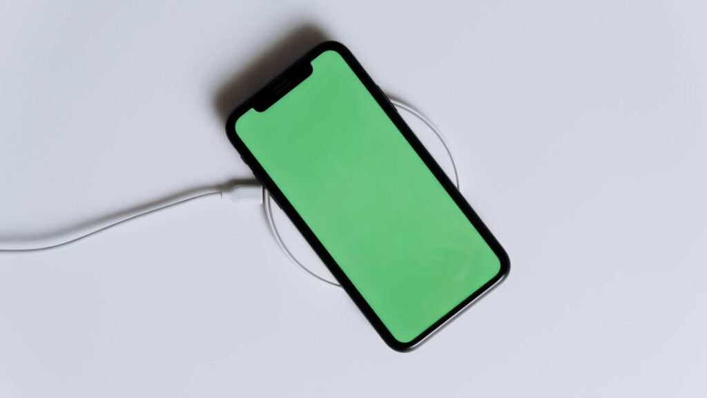 Telefonas padėtas ant belaidžio įkroviklio, bet nesulygiuotas su įkrovimo ritės centru