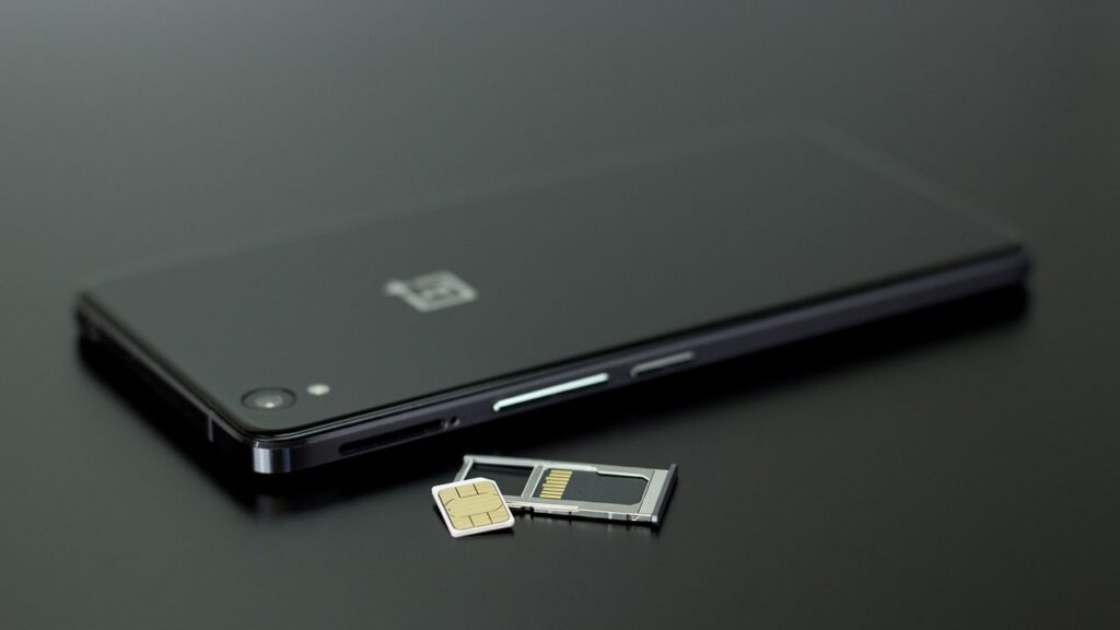 Rankoje laikomas Xiaomi telefonas su atminties kortele šalia – vidinės saugyklos plėtimo būdas