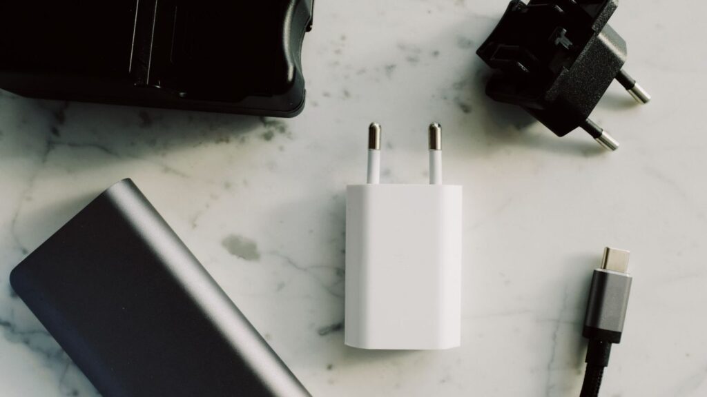 Nešiojamas kompiuteris, prijungtas prie USB-C įkroviklio ant darbo stalo
